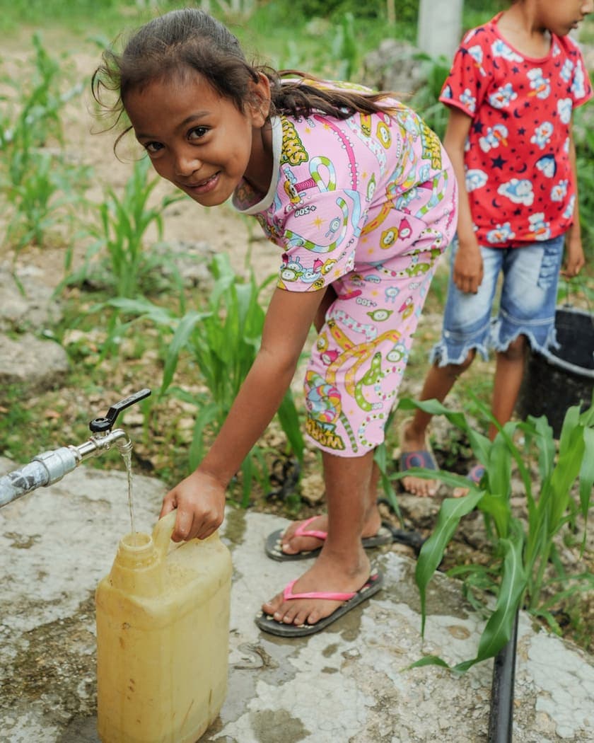 Village children filling a jerrycan from a clean water tap